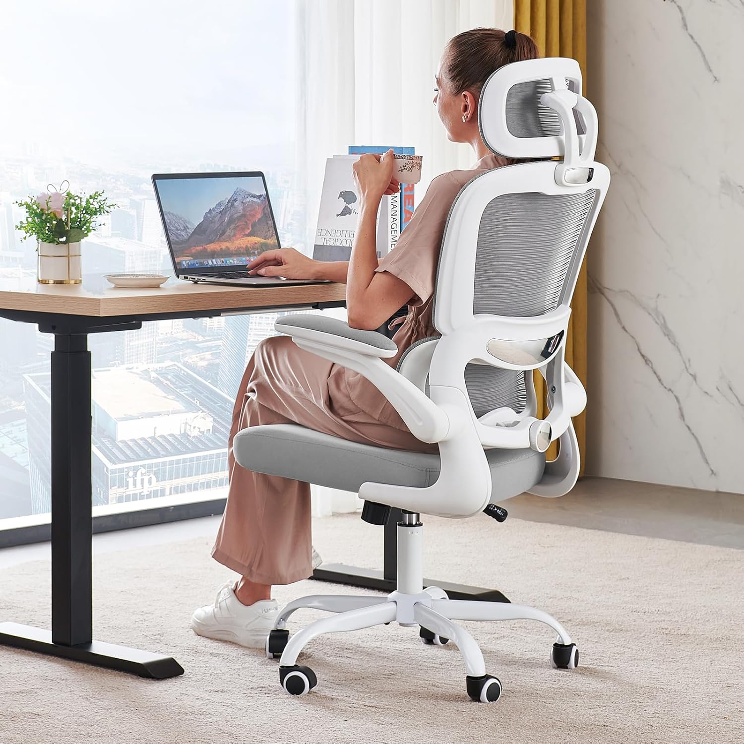 TRALT white ergonomic mesh office chair with headrest and flip-up arms at a home desk